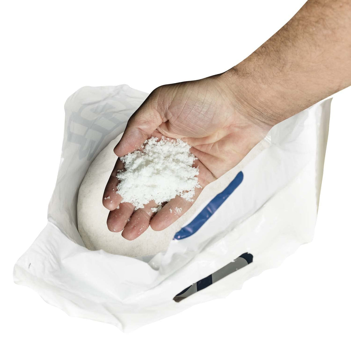 Hand holding fine white pool salt over an open bag.