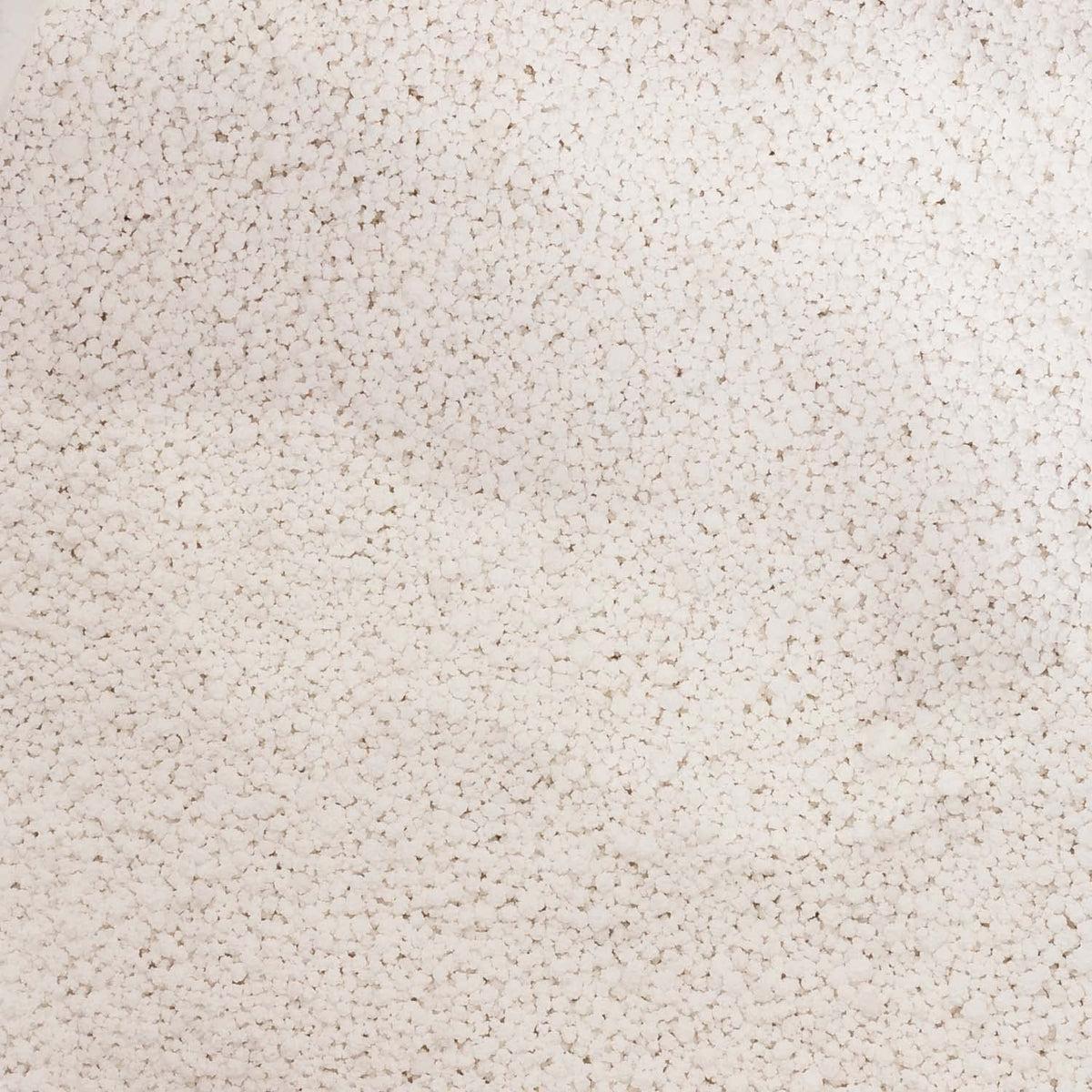 Close-up of white calcium chloride pellets.