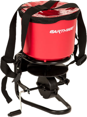 Earthway 40 lb chest mount spreader, red hopper with a black cover, shoulder harness and hand crank.