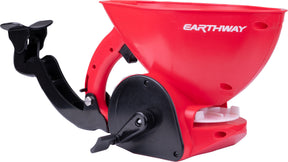 Earthway red hand spreader with a black flip-down armrest and a crank handle.