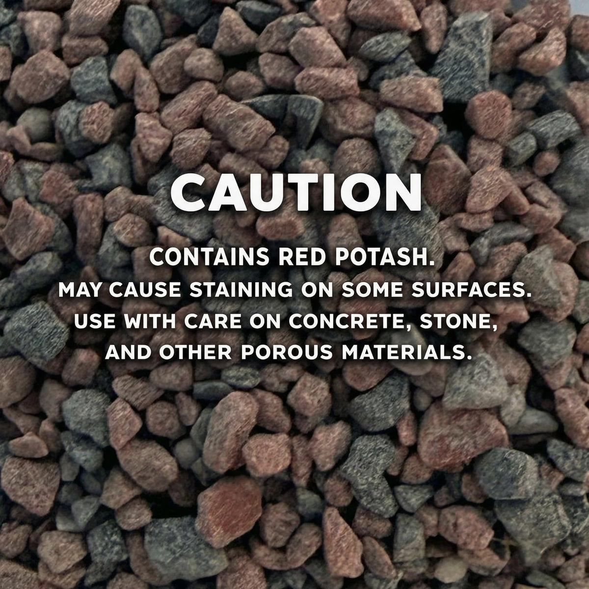 Close-up of red and gray stone granules, printed caution, red potash may stain some surfaces.