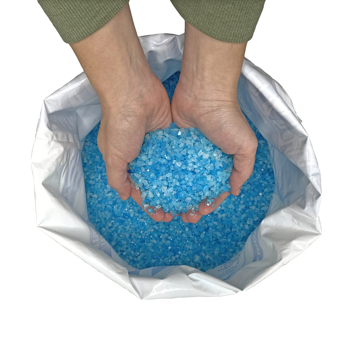 Hands holding blue Emperor Melt ice melt granules over an open 50 lb bag.