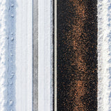 Overhead view of orange ice melt granules spread down a dark driveway between snow.